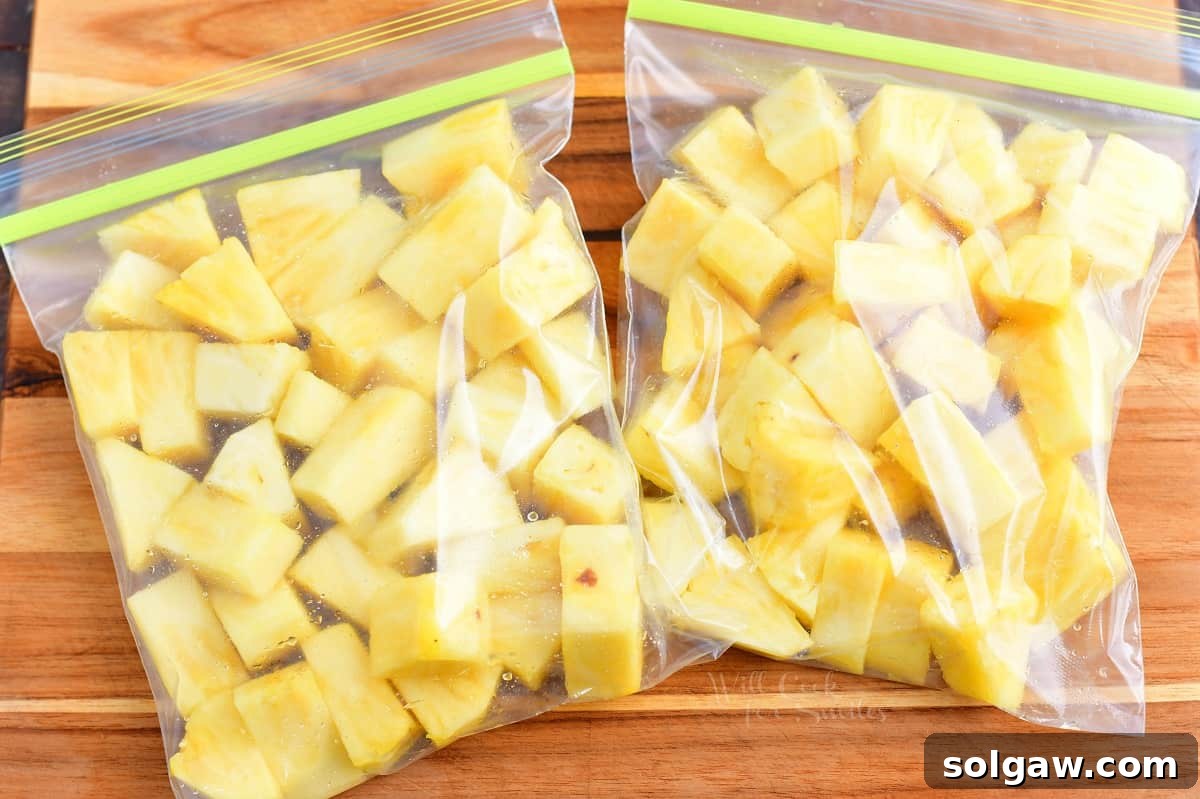 Two ziplock bags filled with frozen pineapple chunks, ready for long-term storage or use in smoothies.