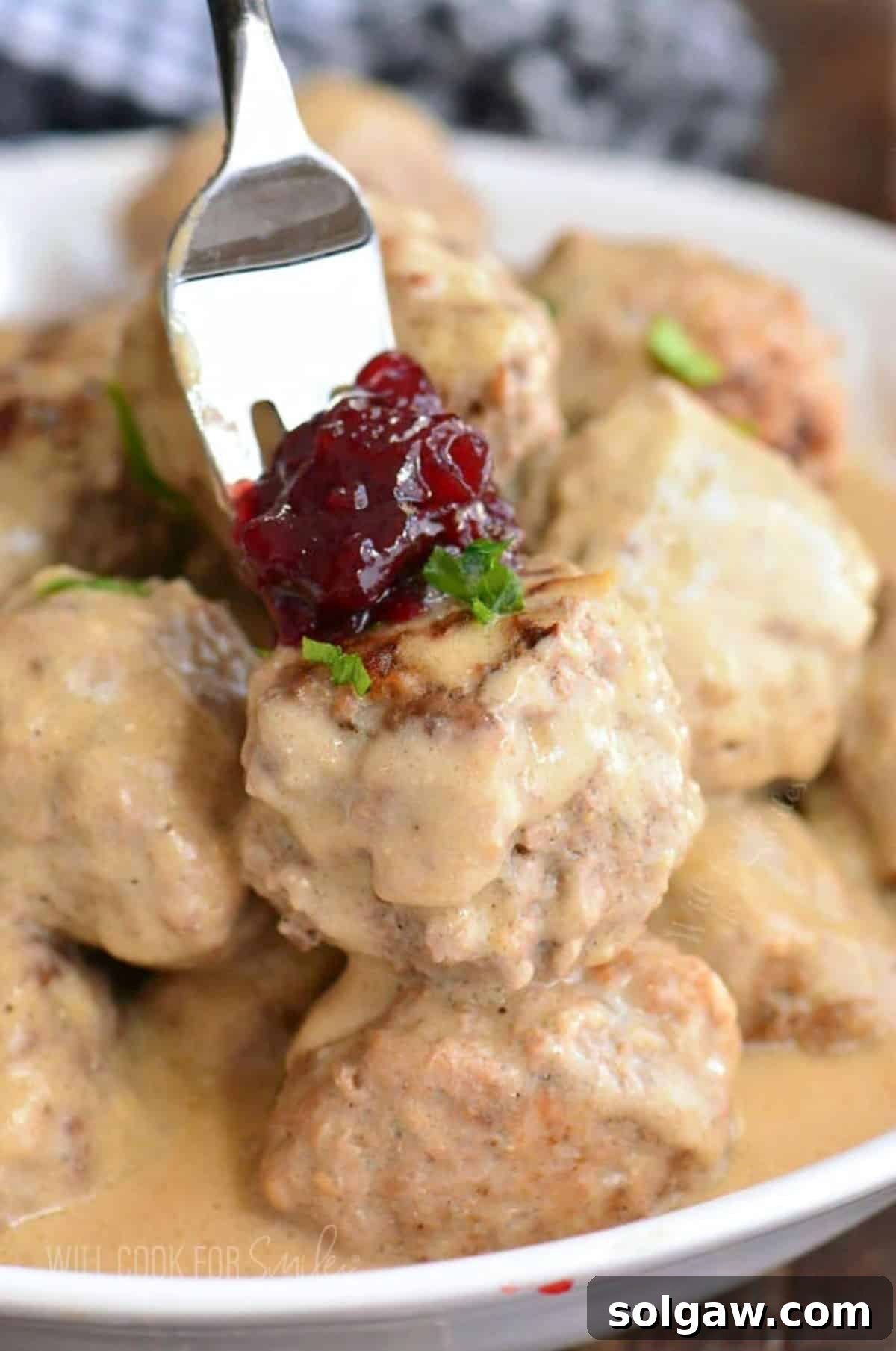 Creamy Swedish Meatballs 10 A top-down shot of a large plate overflowing with perfectly cooked Swedish meatballs, lavishly covered in their rich, creamy brown gravy, inviting you to dig in.