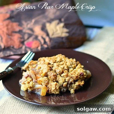 One portion of Asian Pear Maple Crisp served on a black plate with a fork, beautifully presented on a burlap-style placemat.