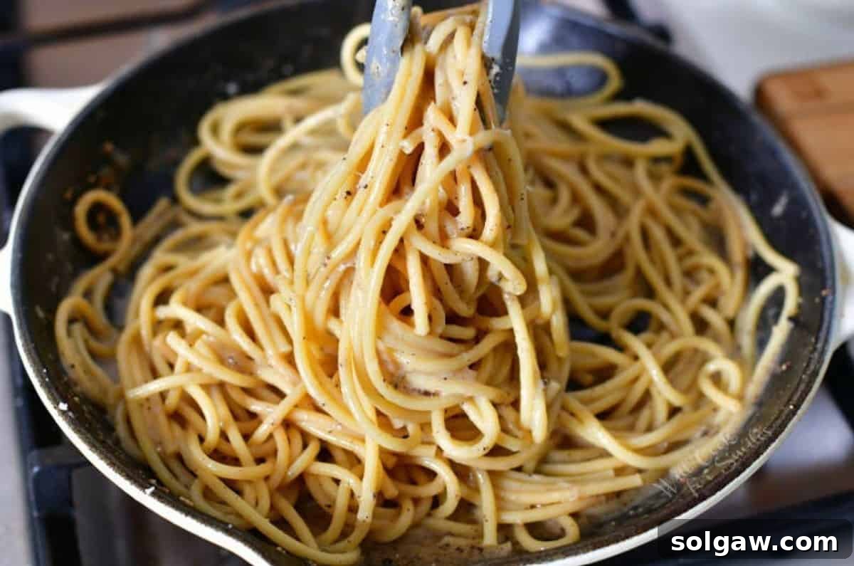 The Creamy Pepper Parmesan Pasta 5 Mixing the al dente pasta with the freshly made pepper and cheesy sauce in a large cooking pan.