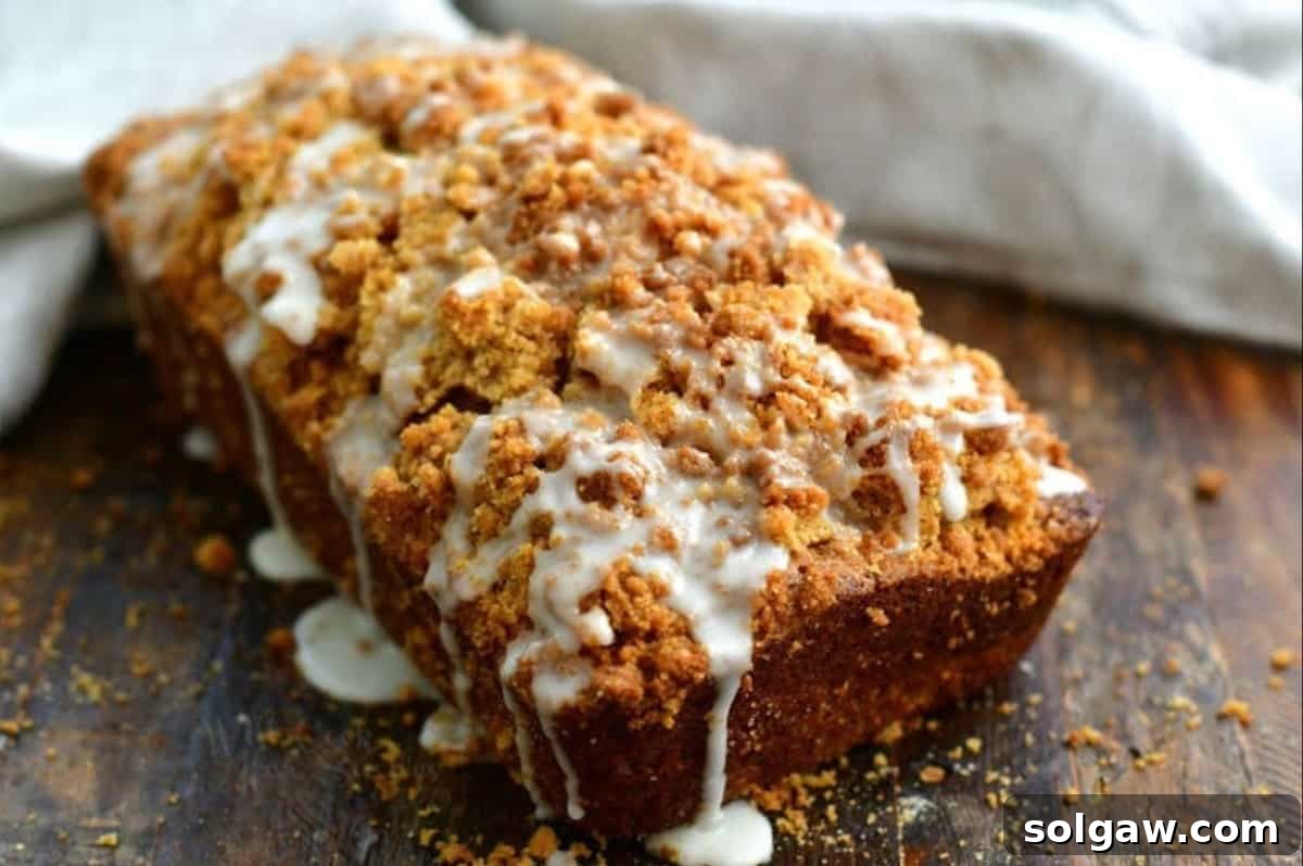 Zucchini Loaf Perfection 7 A freshly baked loaf of zucchini bread topped with a glistening white icing drizzle, cooling on a rack.