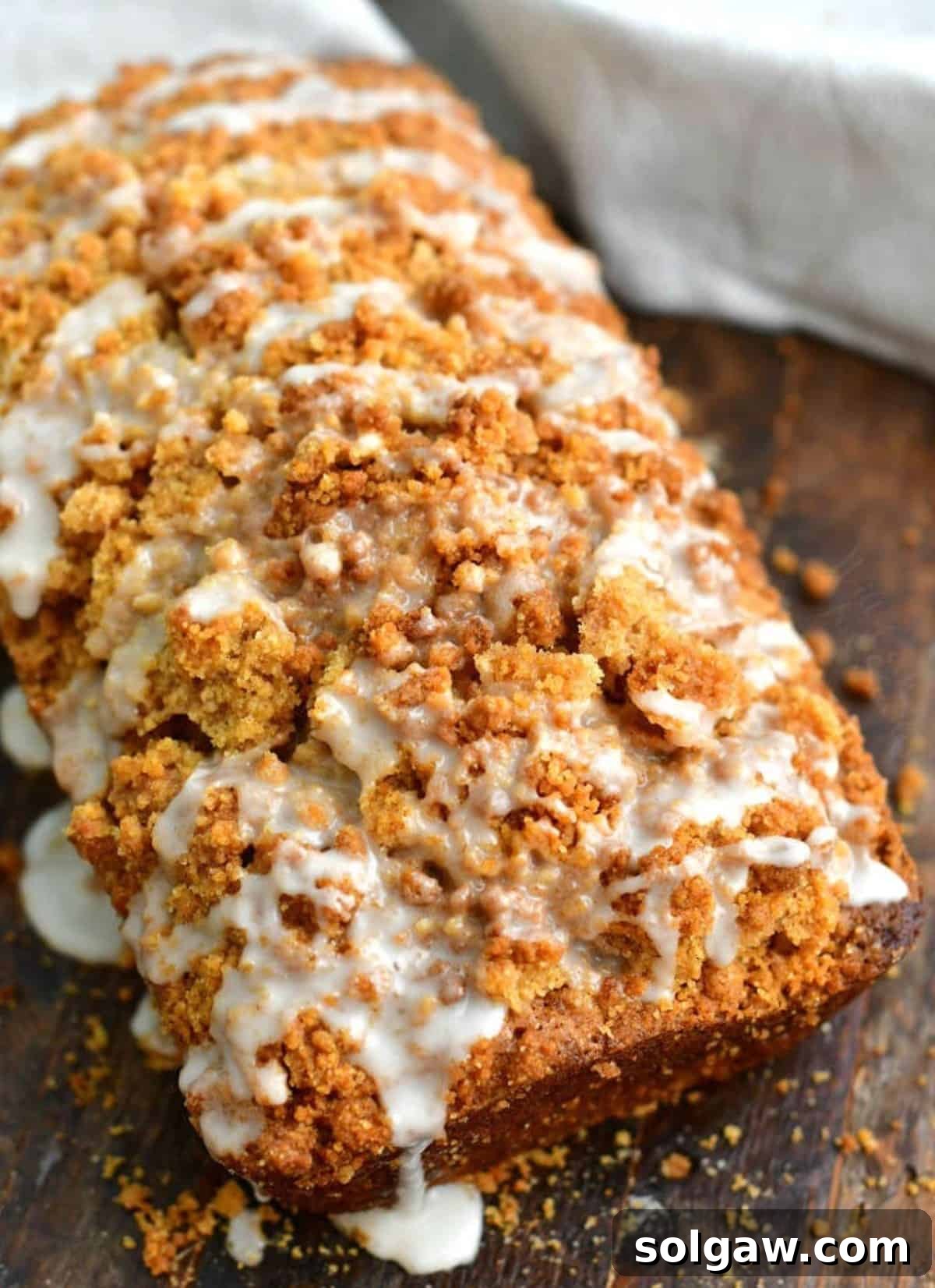 Zucchini Loaf Perfection 8 A full loaf of freshly baked zucchini bread, topped with a generous cinnamon streusel and a delicate white icing drizzle, ready for serving.