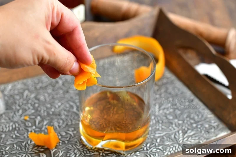 woman's hand rimming cocktail glass with juice from orange