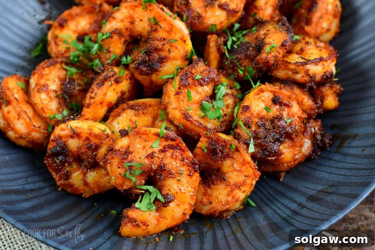 Smoky Cajun Shrimp 6 a pile of cooked blackened shrimp on a bowl topped with some parsley.