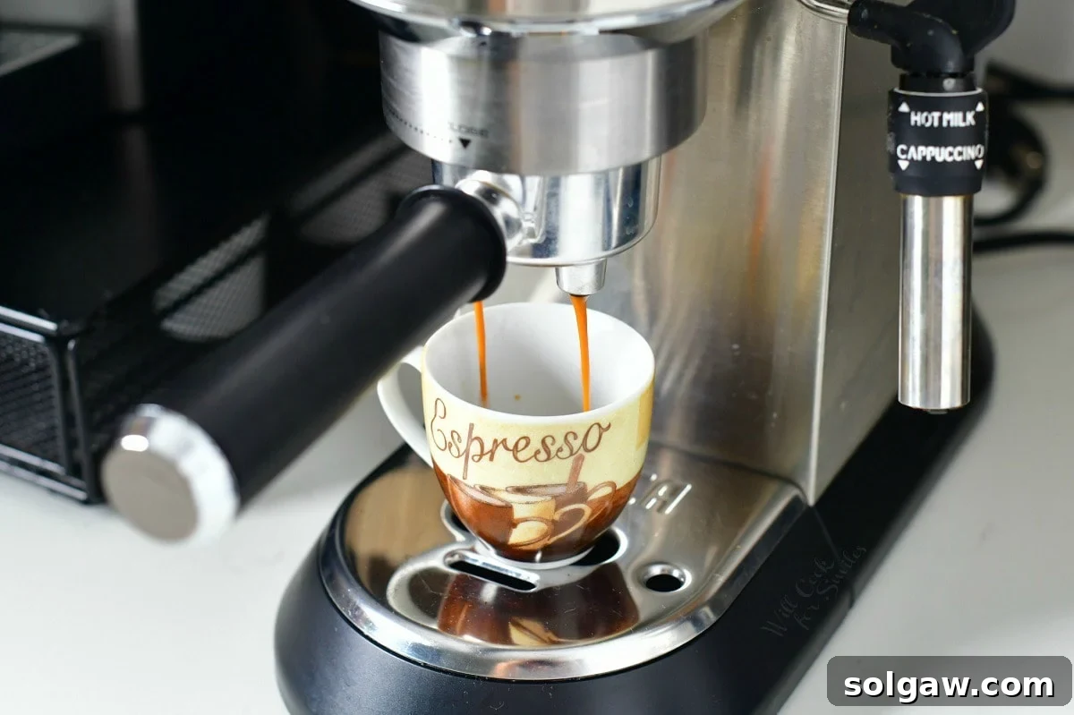 Espresso machine pouring a rich, dark espresso shot into a small ceramic mug.