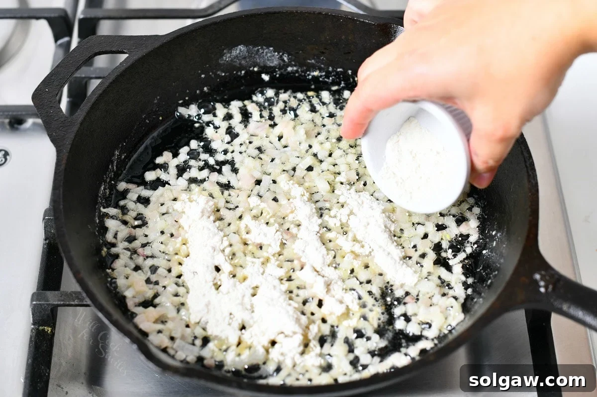 adding white flour to a skillet of buttery onions to make roux