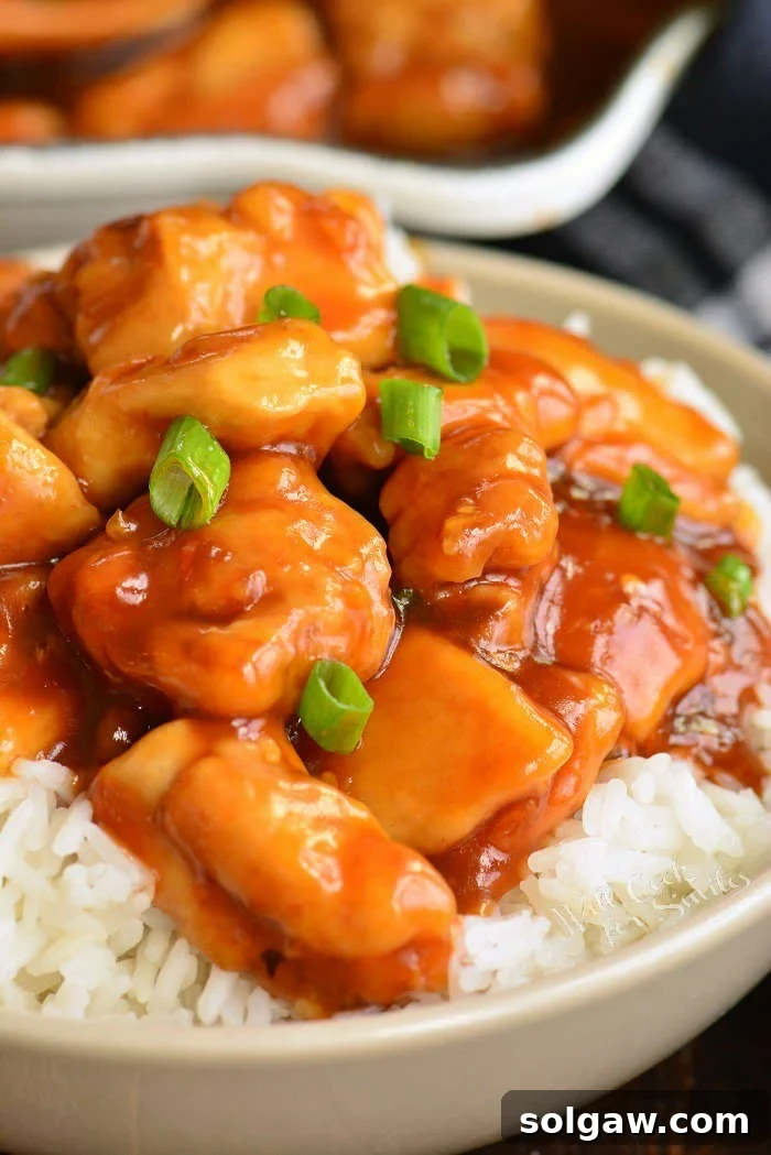 bourbon chicken in a bowl, garnished with scallions