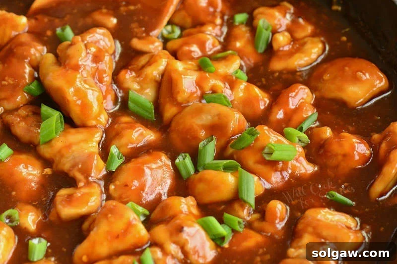 bourbon chicken cooking in a pan, fully coated in sauce