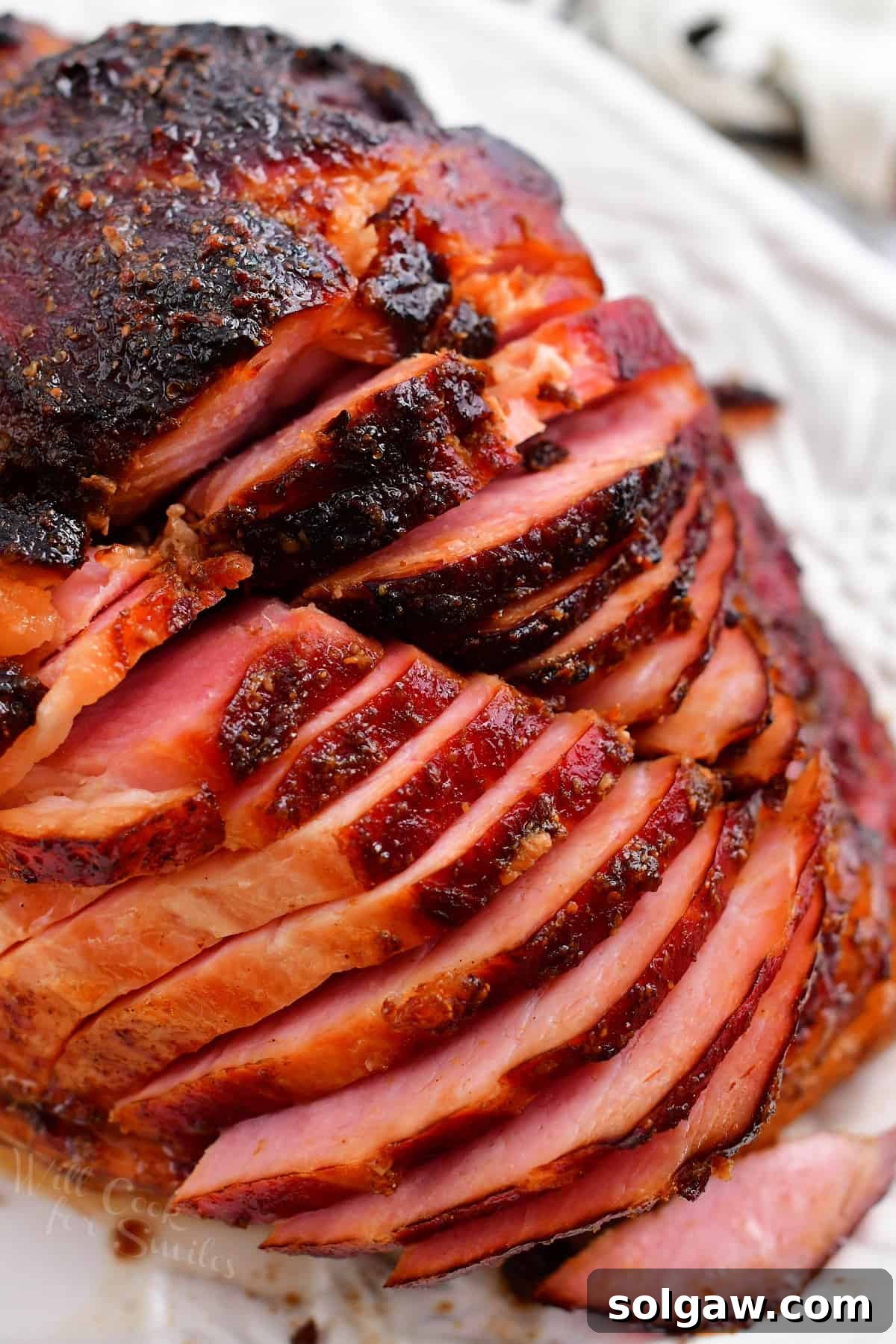Signature Bourbon Glazed Ham 9 slices of glazed ham on white platter