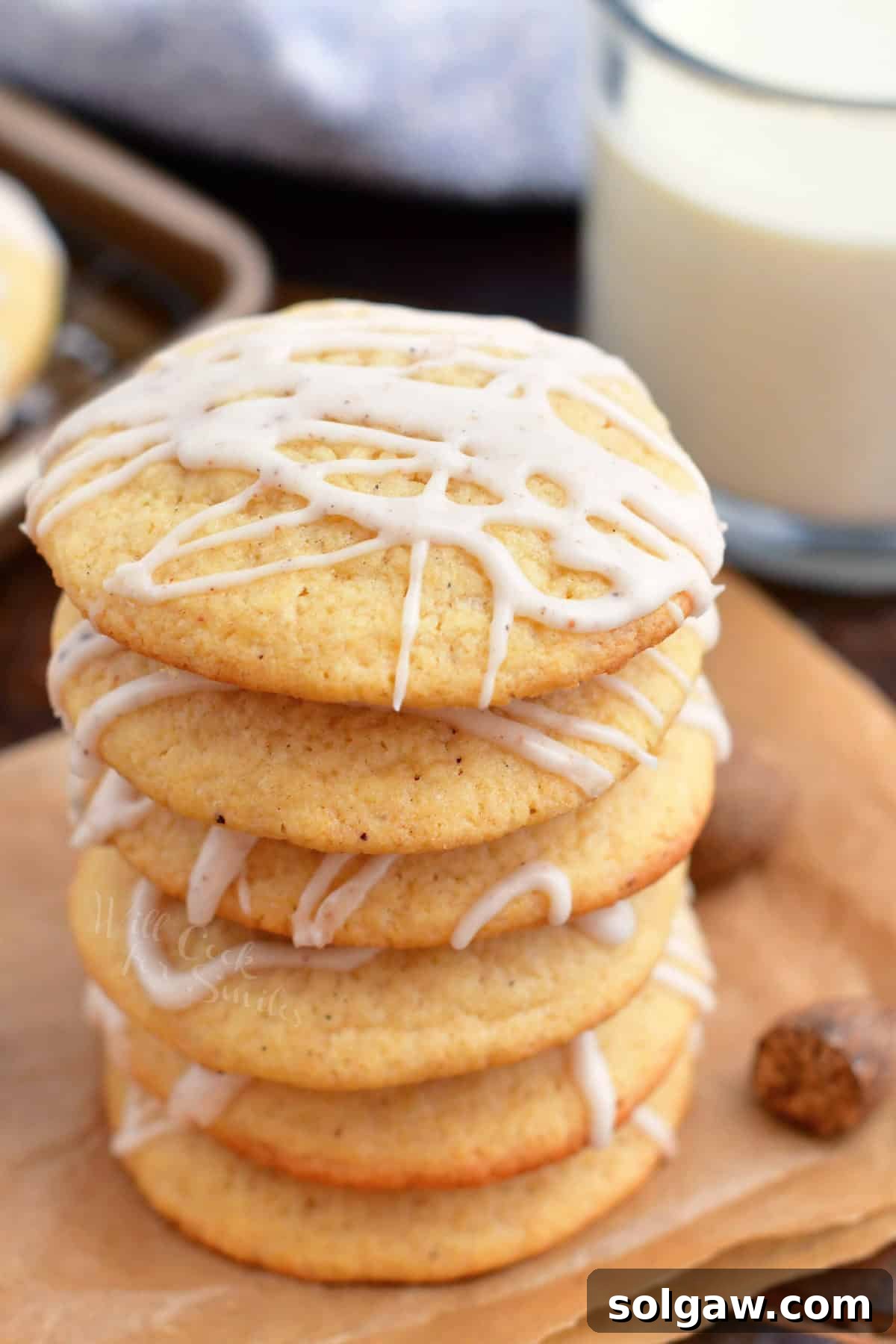 Stacked soft eggnog cookies on an orange napkin, ready for holiday festivities.