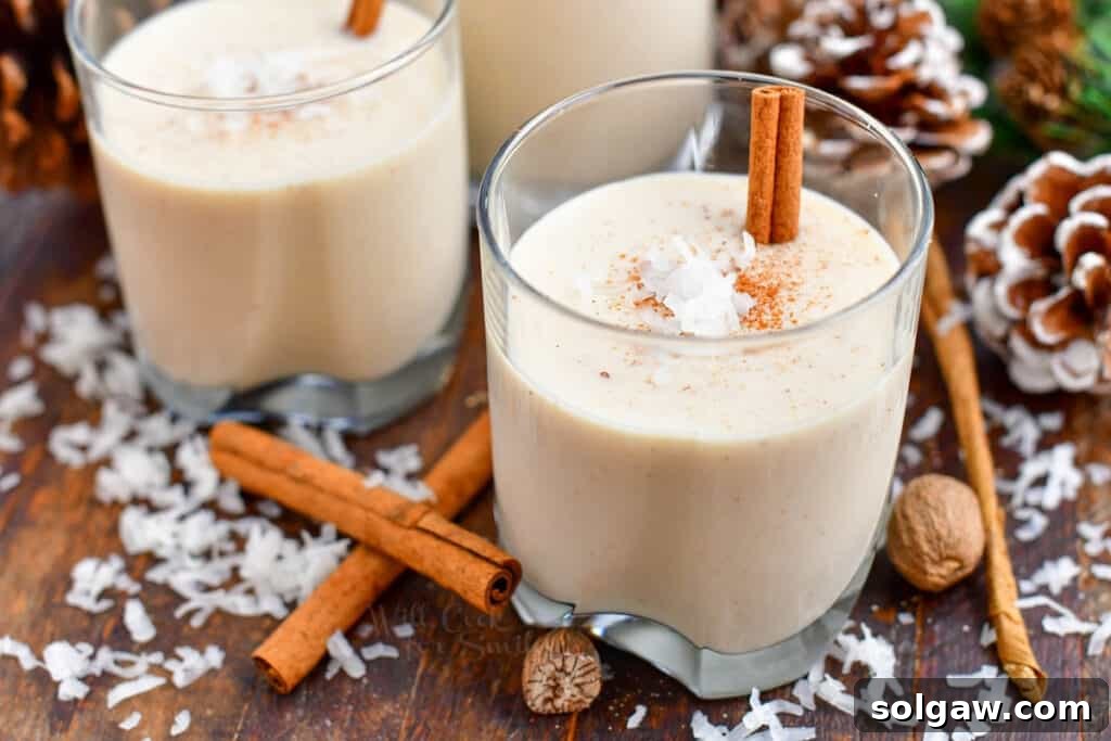 Side view of two exquisite Christmas cocktails featuring rum, elegantly presented in classic lowball glasses, ready for a festive toast.