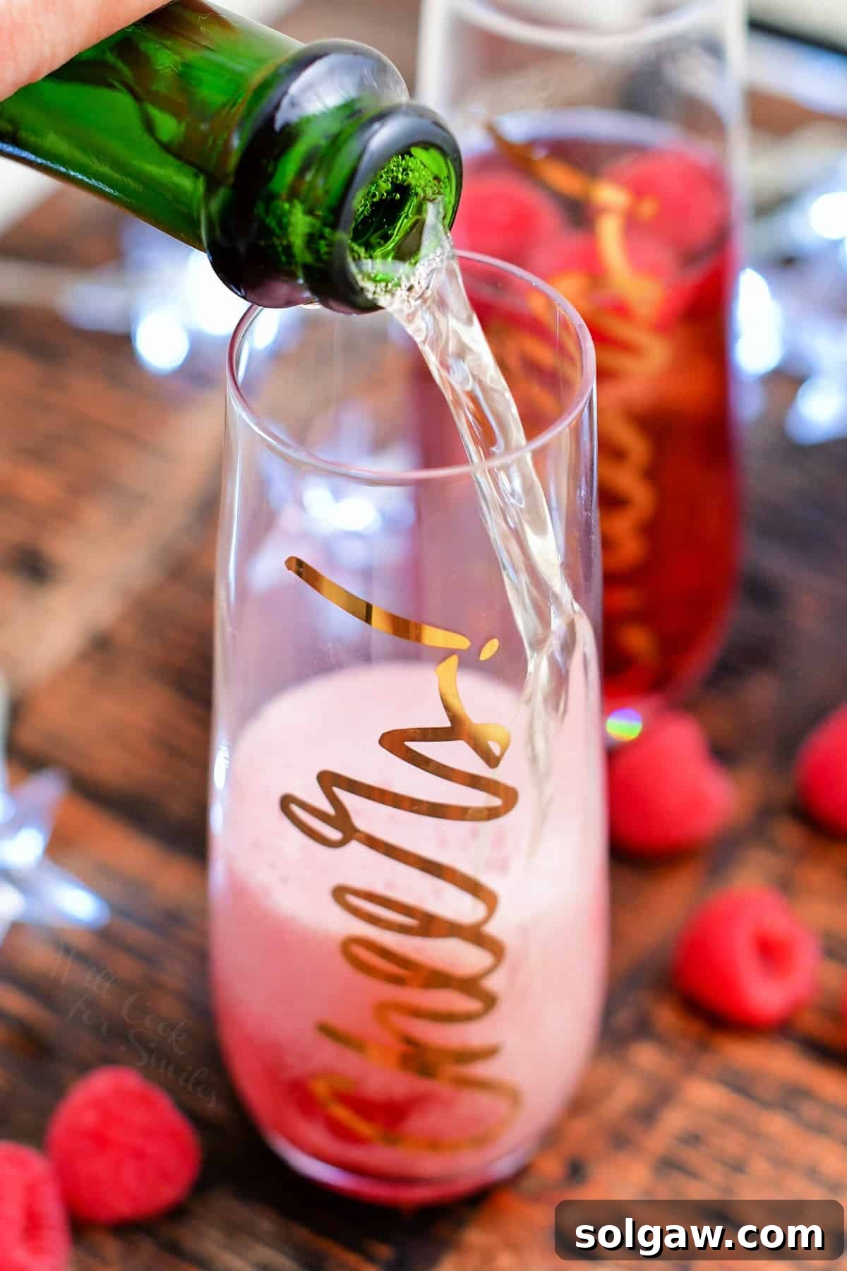 adding champagne to a glass for a Kir Royale recipe