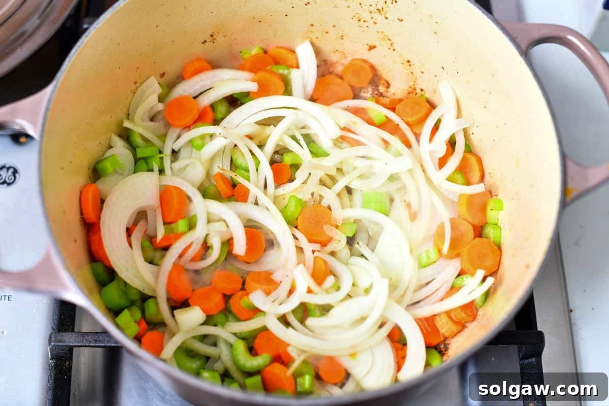 overhead: diced carrots, celery, and onion in large pot on stove top