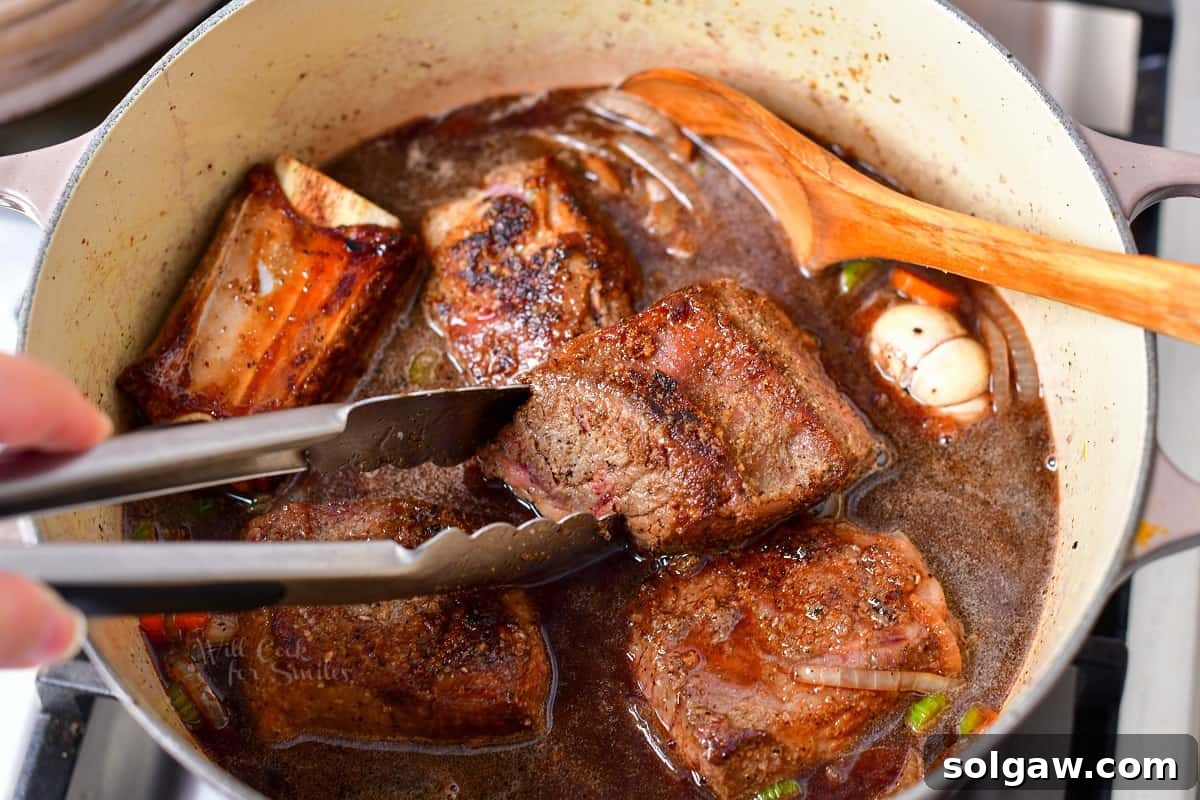 braised short ribs cooking in large pot on stove top