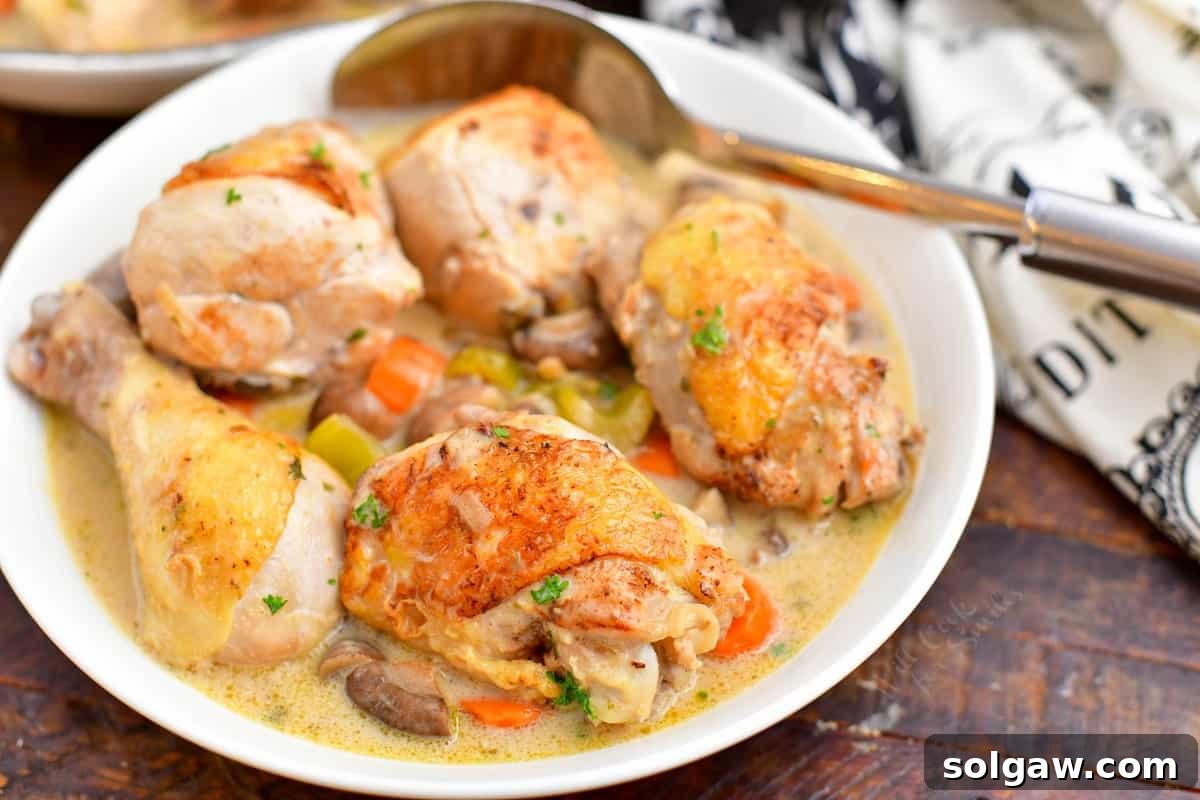 Close-up of a serving bowl filled with French Chicken Fricassee and a spoon, ready to be enjoyed.