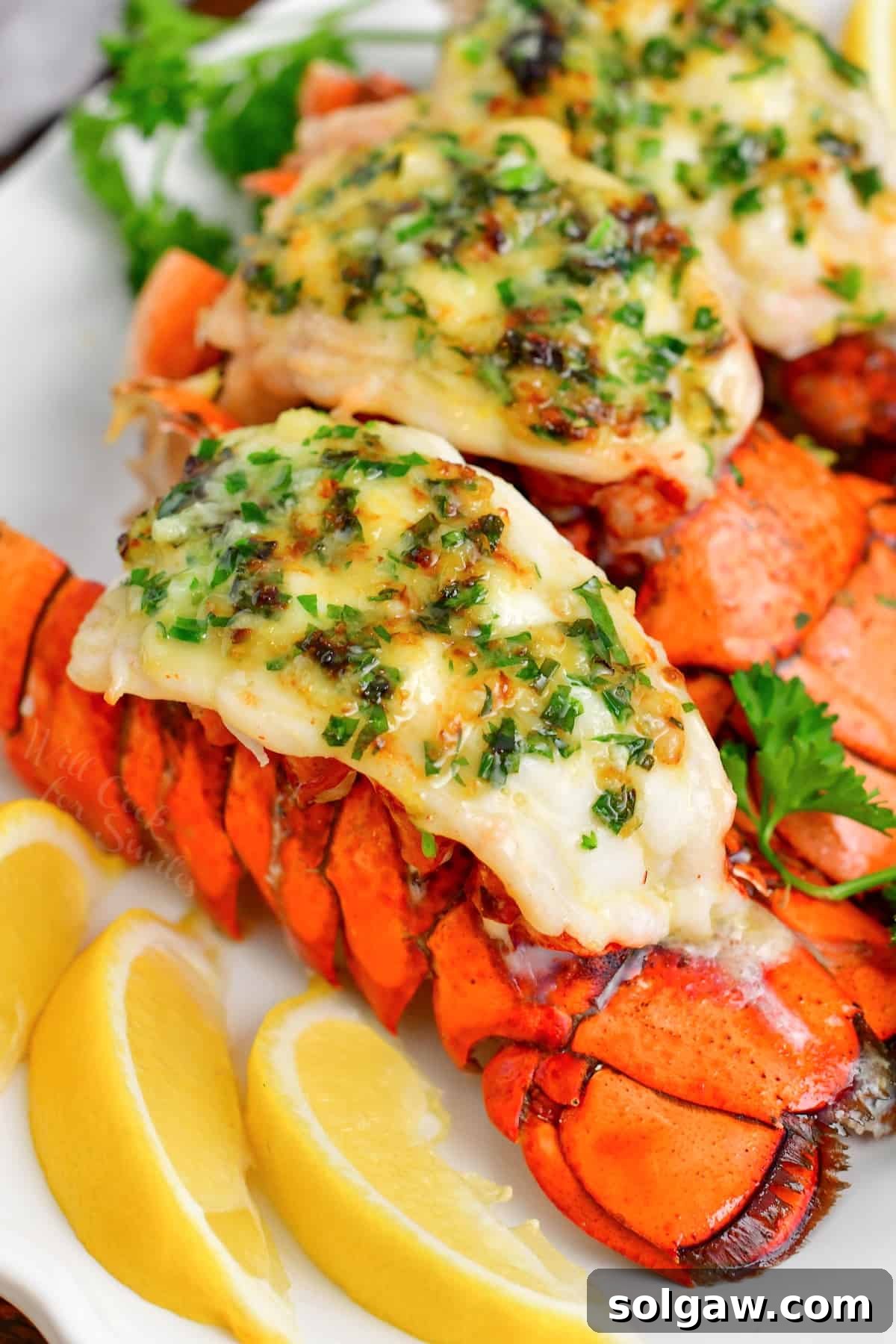 baked lobster tails topped with fresh parsley and herb butter