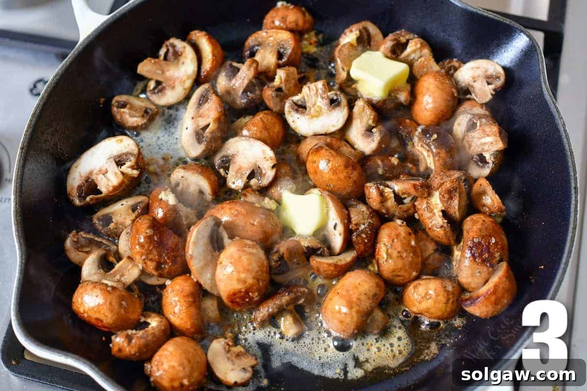 Adding butter to cooking mushrooms in a hot skillet for richness