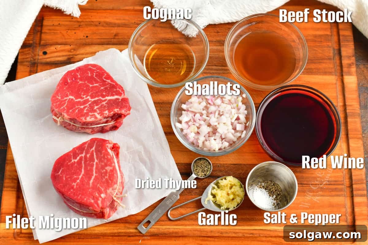 Labeled ingredients for red wine steak sauce including shallots, garlic, cognac, red wine, beef stock, and butter laid out on a cutting board.