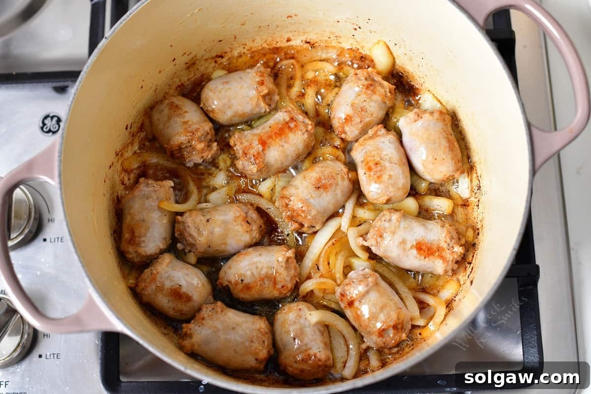 Dublin Coddle: Classic Irish Sausage and Potato Stew 5 Sausage pieces and sliced onions are gently cooking in a large pot, beginning to brown and release their aromas.