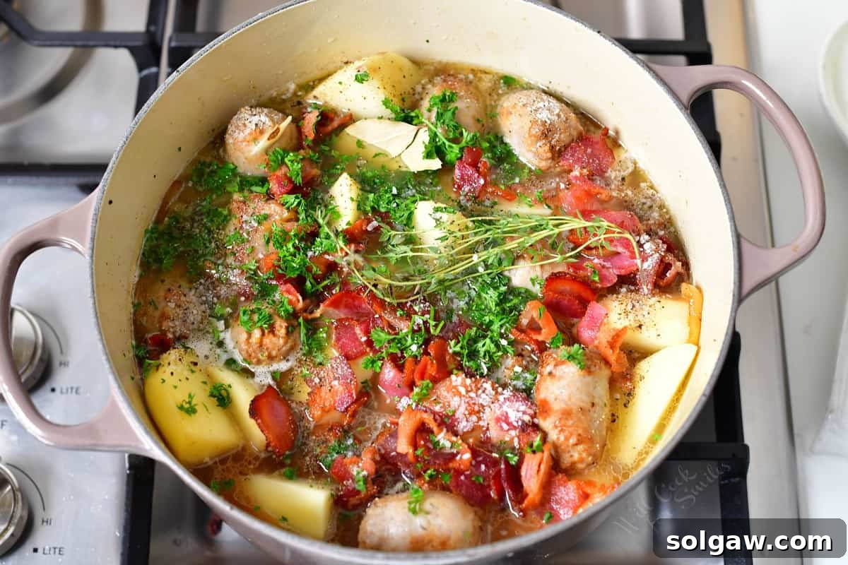 Dublin Coddle: Classic Irish Sausage and Potato Stew 7 A large pot is brimming with all the ingredients for Dublin Coddle, generously garnished with fresh green herbs, ready for simmering.