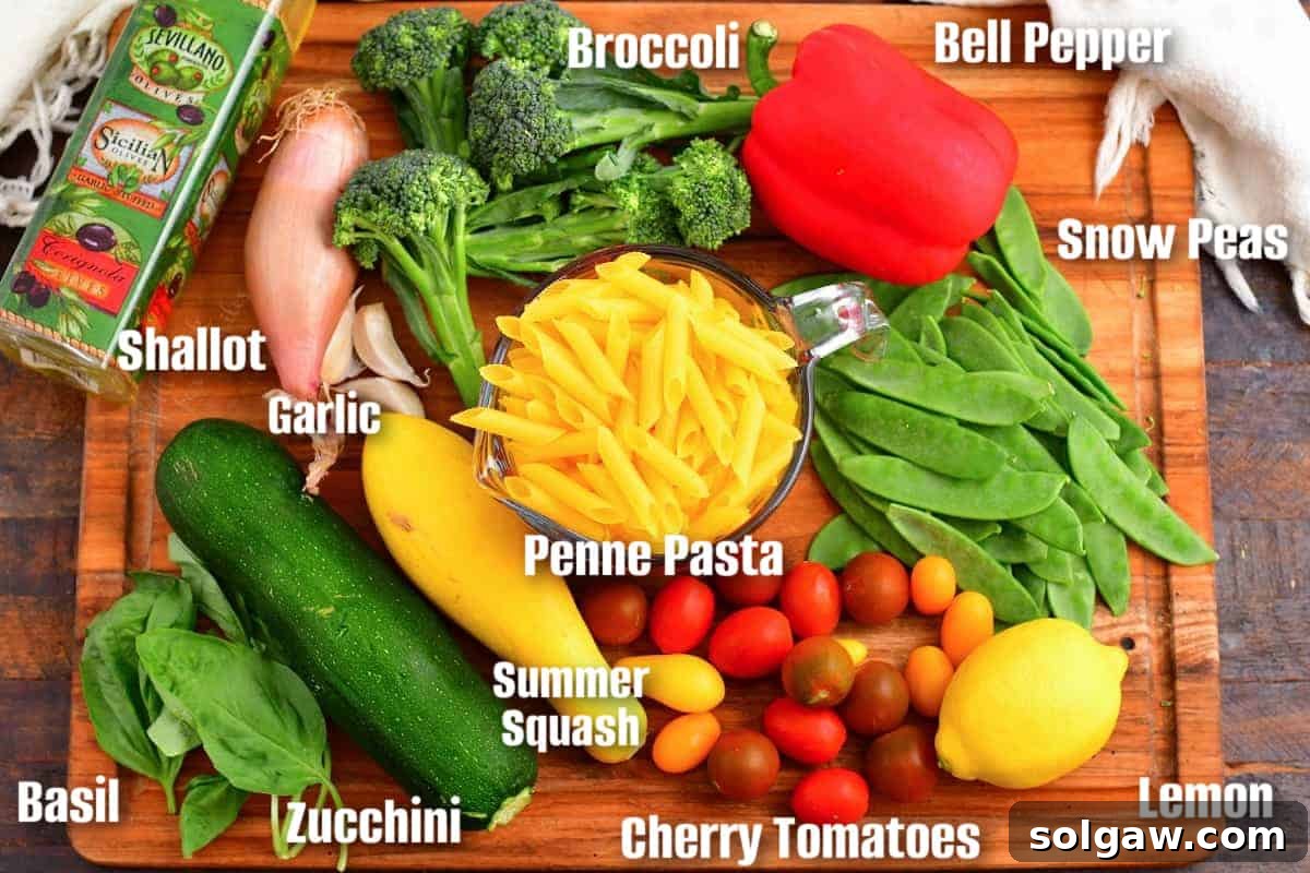 Assortment of fresh vegetables, herbs, and pasta laid out for making pasta primavera.