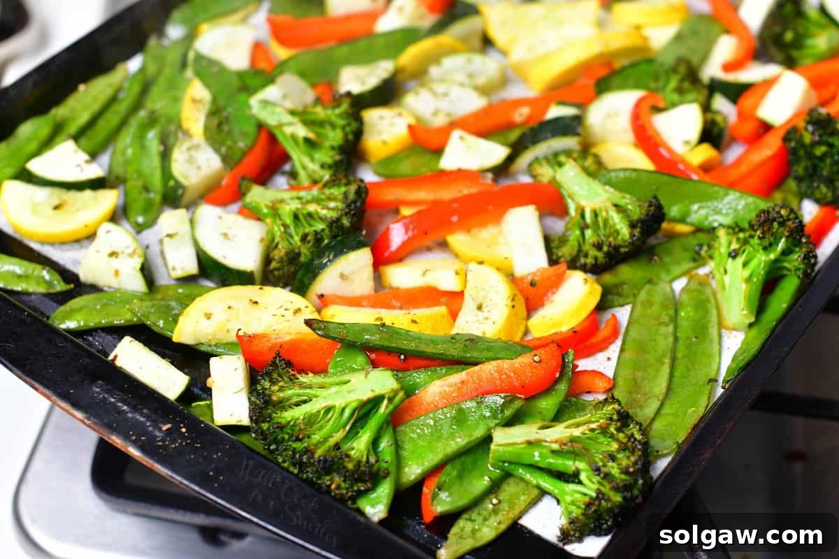 Beautifully roasted vegetables, golden and tender, spread on a baking sheet after coming out of the oven.