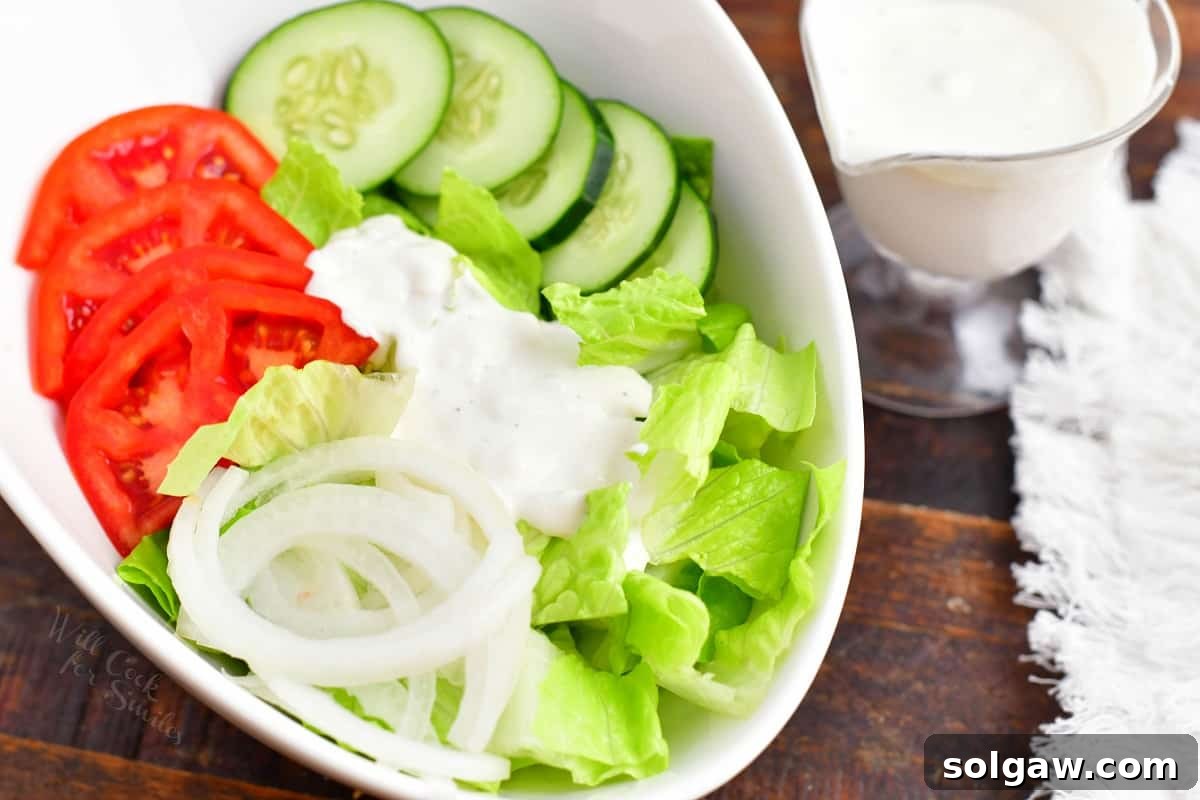 A small amount of blue cheese is drizzled on a chopped salad.