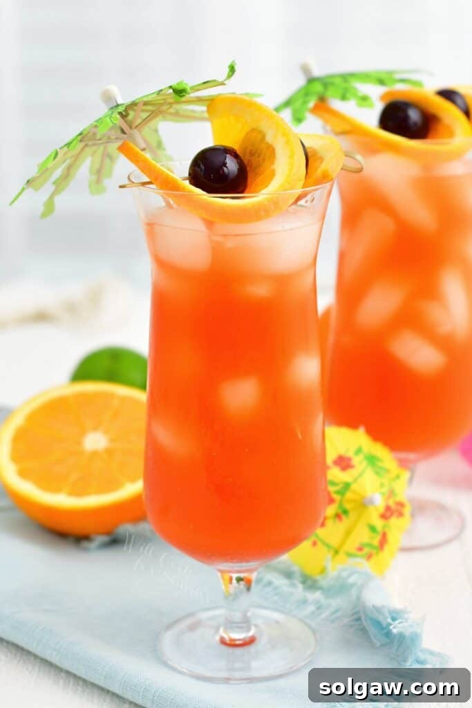 Tropical Rum Bliss 2 A tall glass of rum punch is garnished with fresh fruits and small palm trees, inviting a tropical escape.