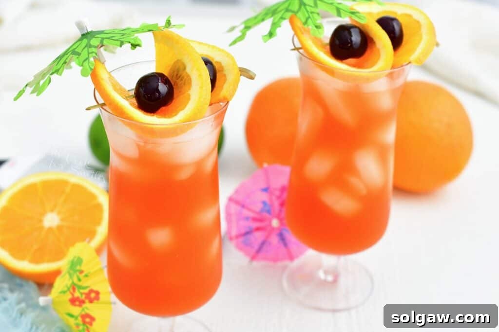 Tropical Rum Bliss 6 Two glasses of sparkling rum punch, elegantly garnished, are placed side by side, ready to be enjoyed.