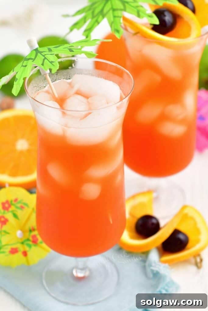 Tropical Rum Bliss 8 Ice cubes gracefully float at the top of a glass overflowing with the refreshing rum punch.