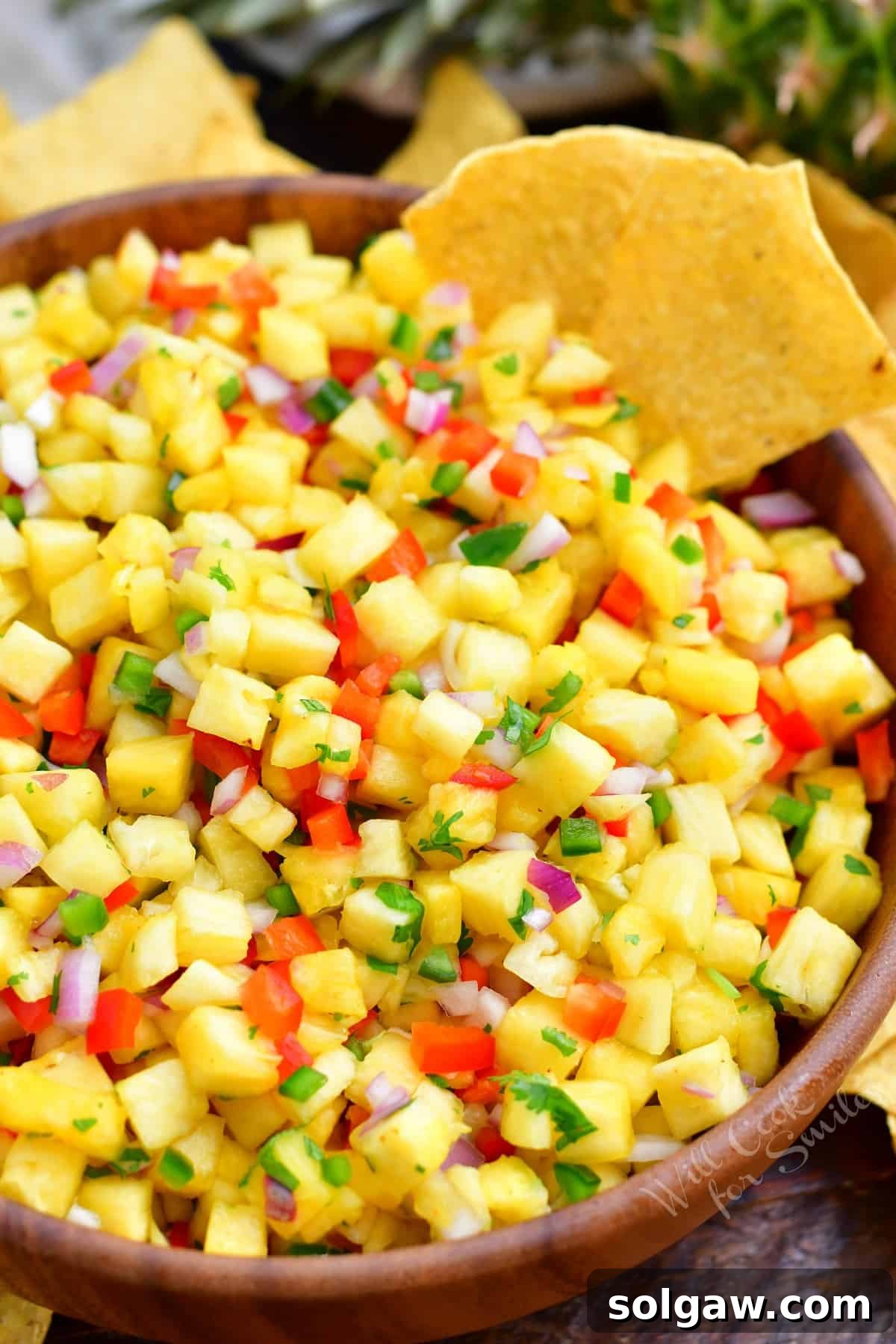 Crisp tortilla chips beautifully arranged around a vibrant bowl of homemade pineapple salsa, a perfect summer appetizer.