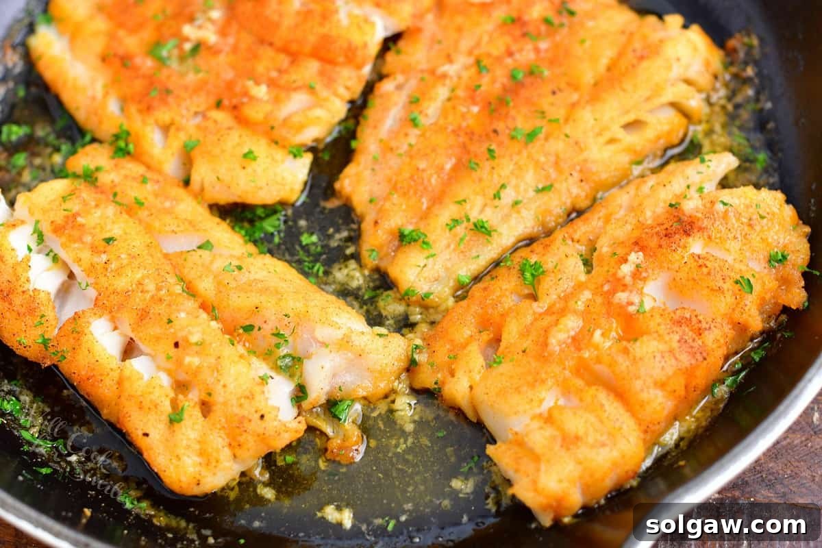 Parsley is garnishing cod filets. 