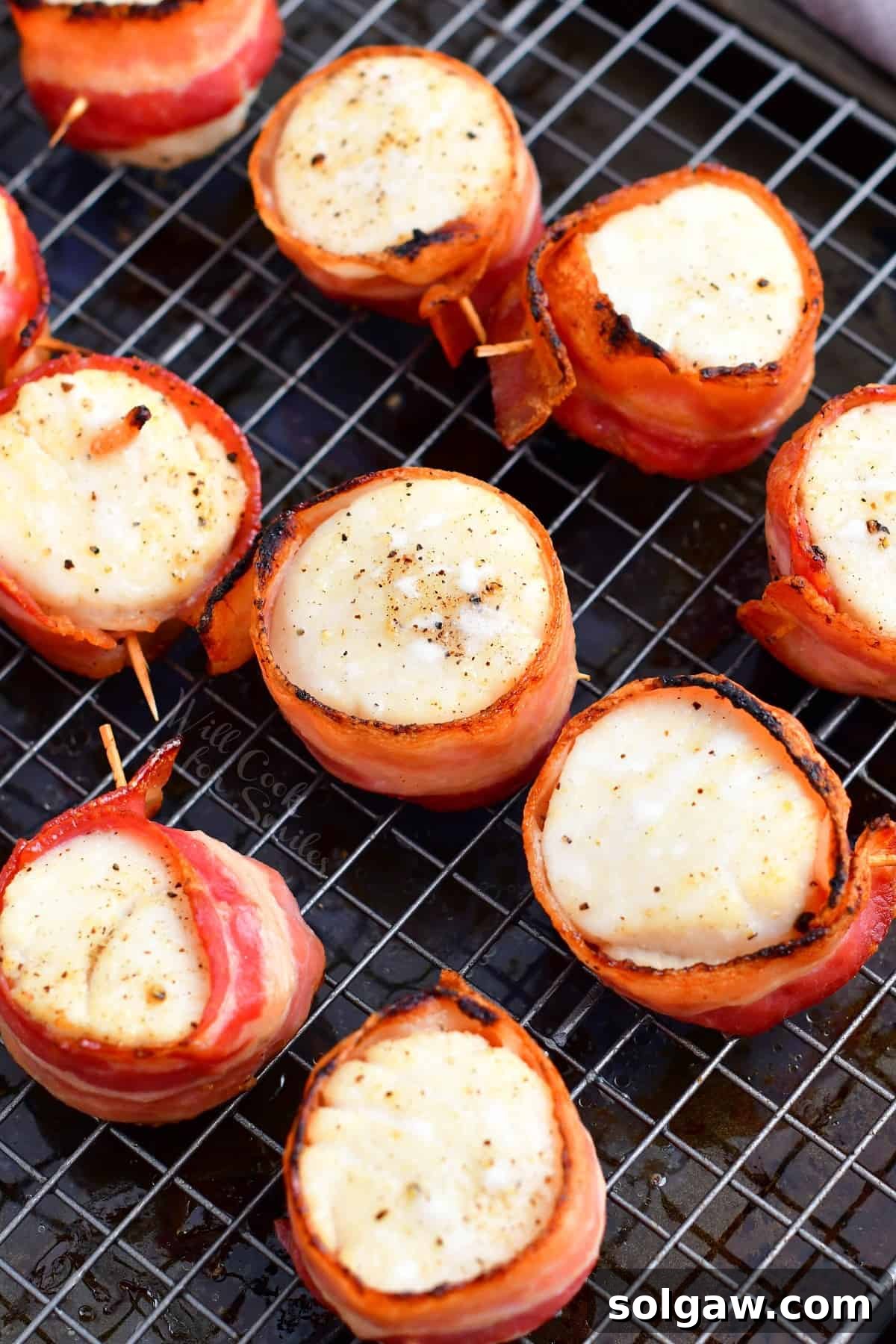 Crispy pieces of bacon are wrapped around perfectly cooked sea scallops, creating an irresistible appetizer.