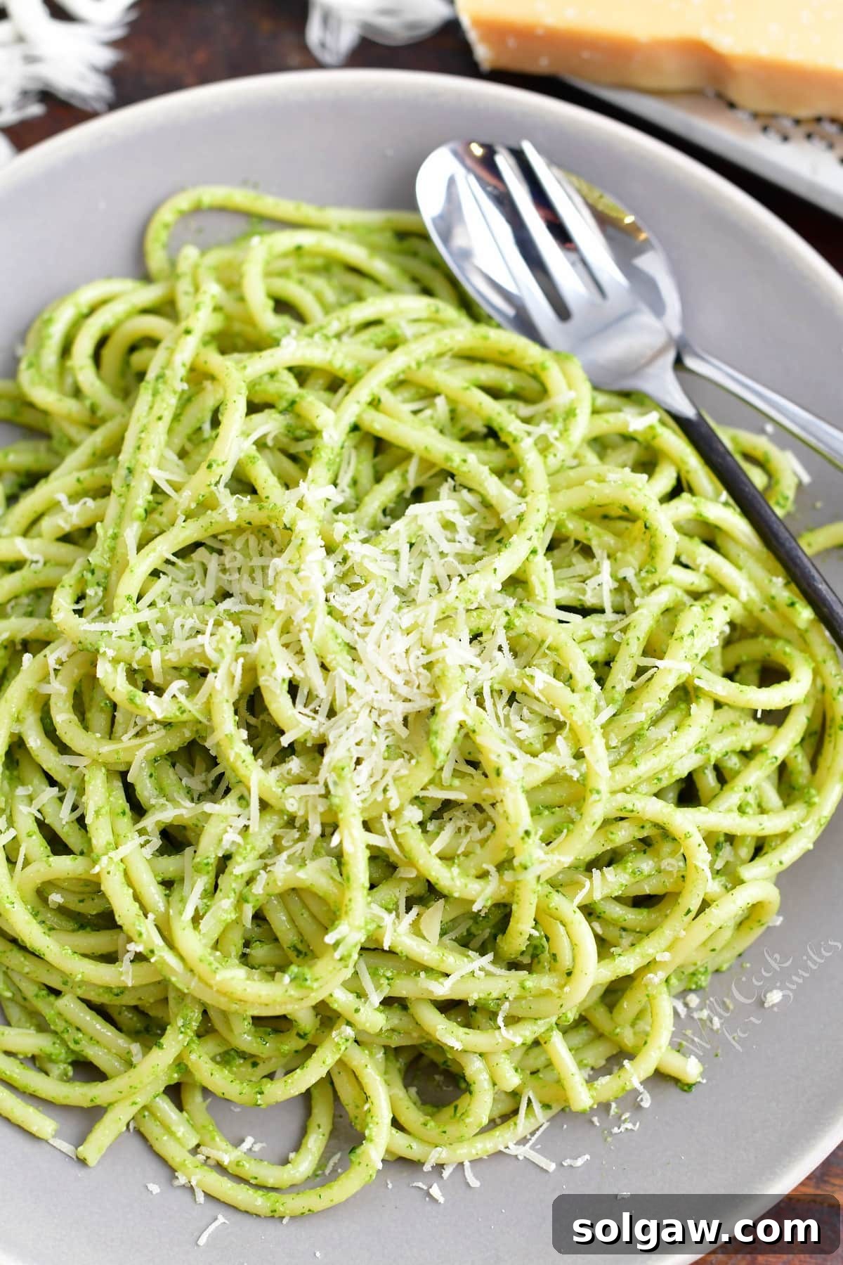 A delectable serving of pesto pasta, plated beautifully with a fork resting on the side, inviting you to savor every rich and fresh bite.