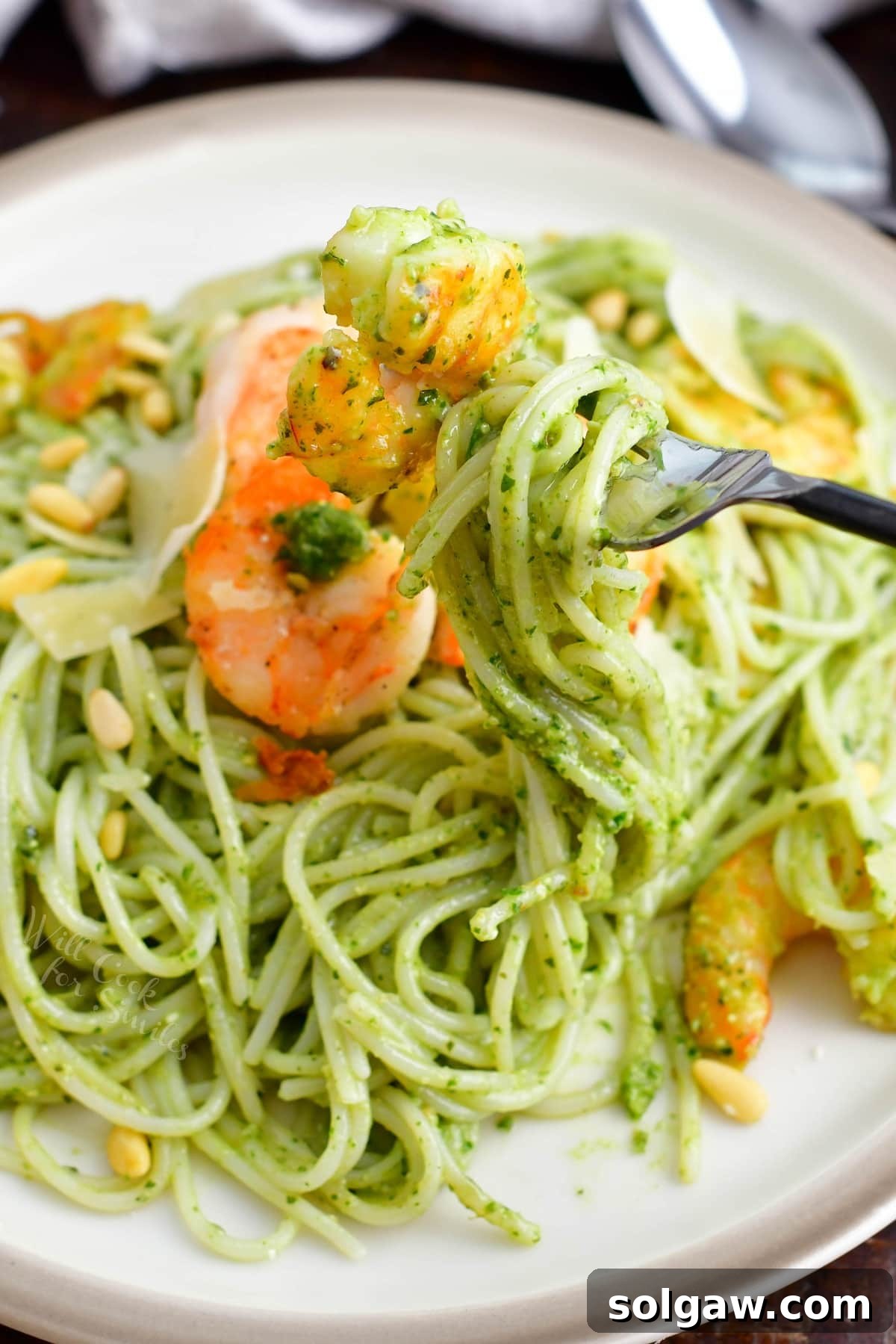Emerald Pesto Shrimp Pasta 5 A fork elegantly twirling a perfect bite of pesto pasta with shrimp, showcasing the vibrant green sauce and tender seafood.