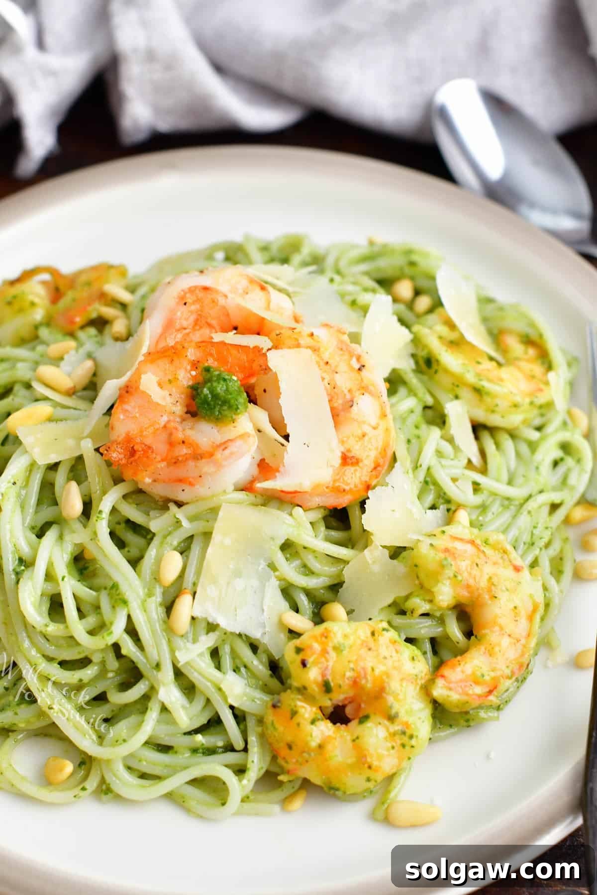Shrimp and cheese garnish a large potion of pesto pasta.