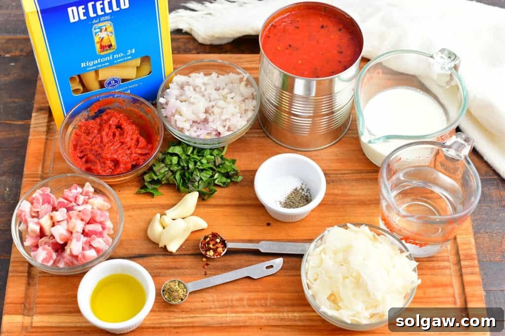 Creamy Tomato Vodka Penne 3 Penne alla vodka ingredients are placed on a wooden board.