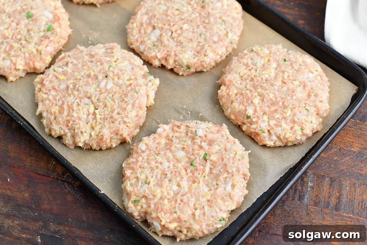 Ultimate Chicken Burgers 5 Several perfectly shaped chicken burger patties resting in a tray, ready for cooking.