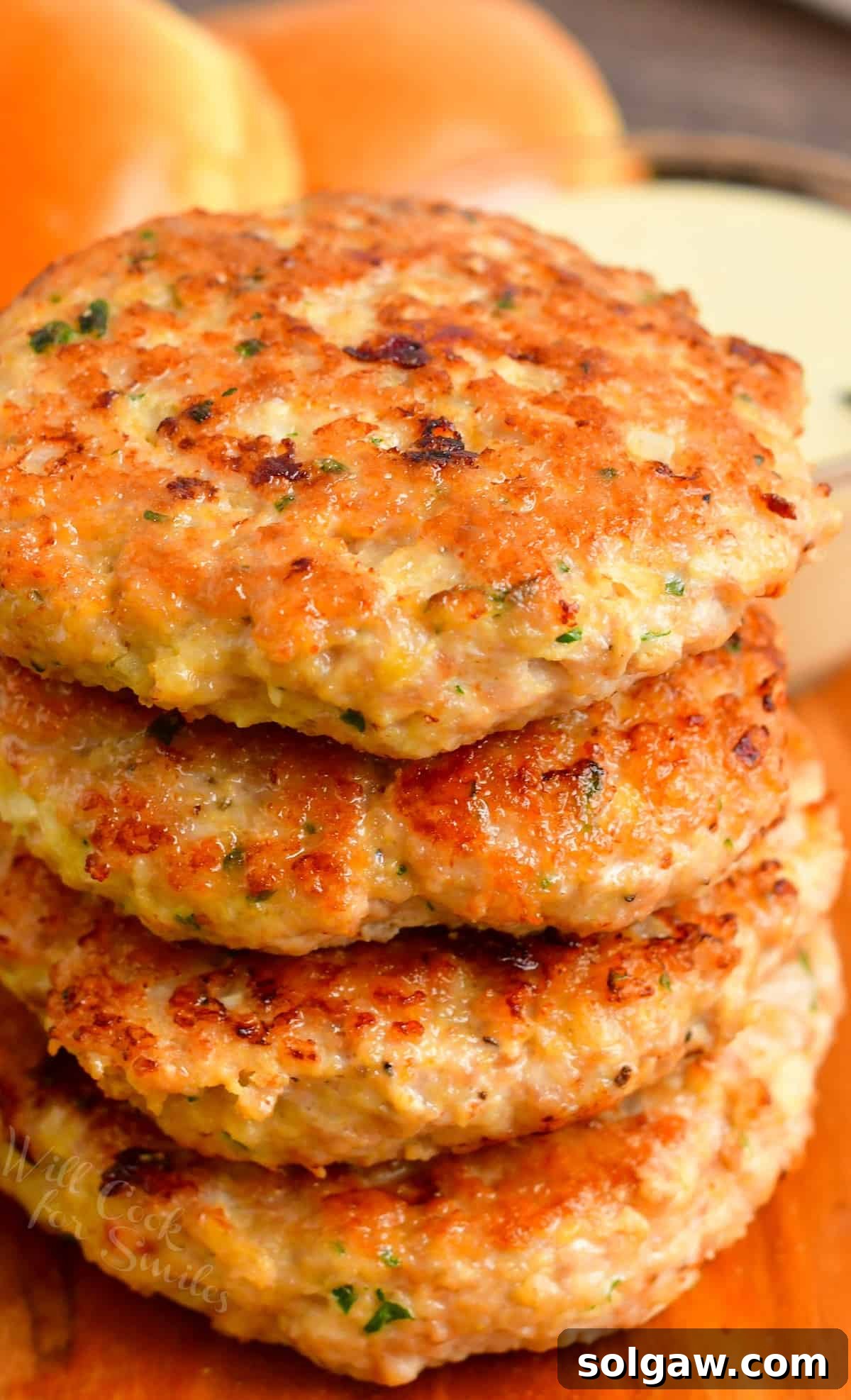 Ultimate Chicken Burgers 7 Four juicy chicken burger patties stacked on top of each other, showcasing their perfect texture and doneness.