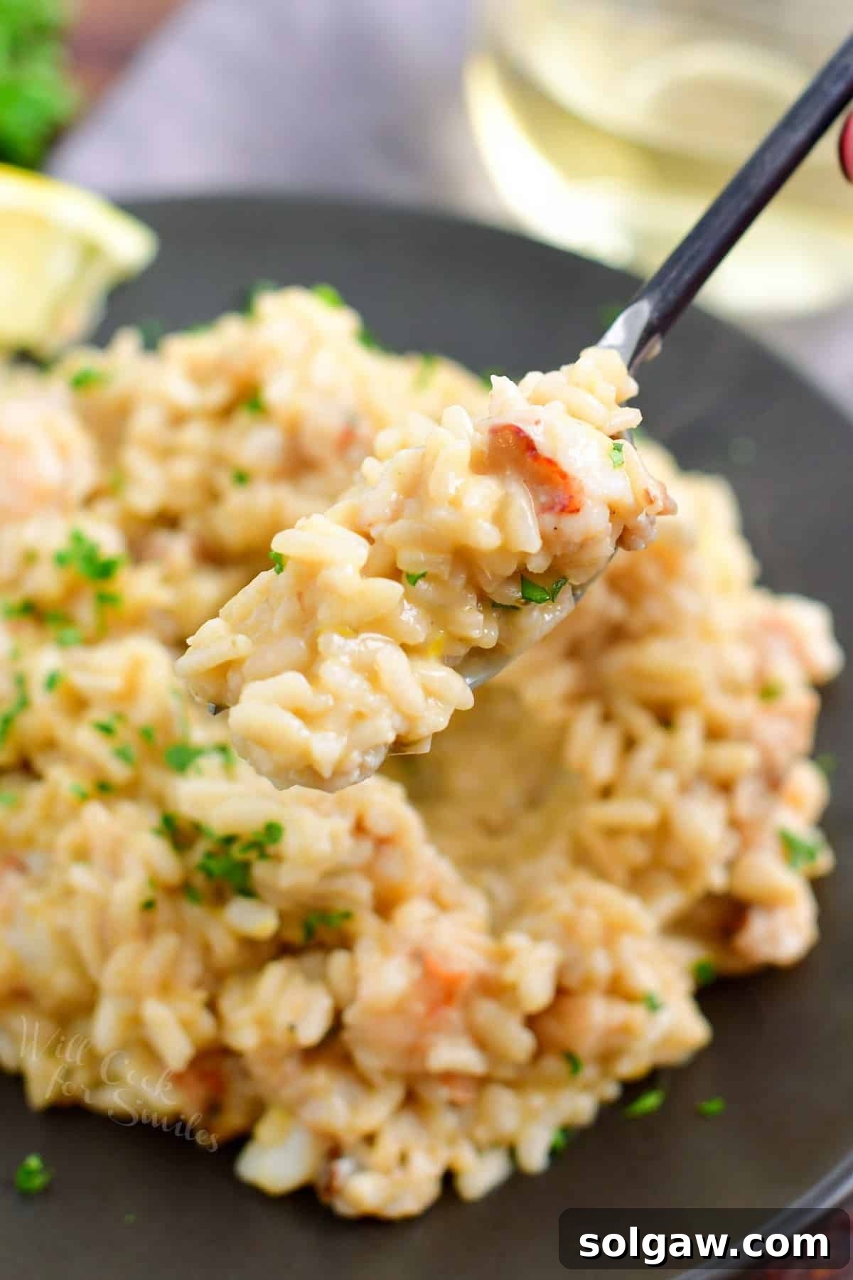 A close-up shot of a fork holding a delicious bite of lobster risotto.