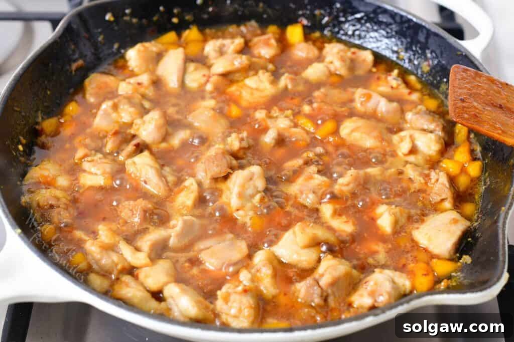 adding chicken to the sauce and cooking in a pan