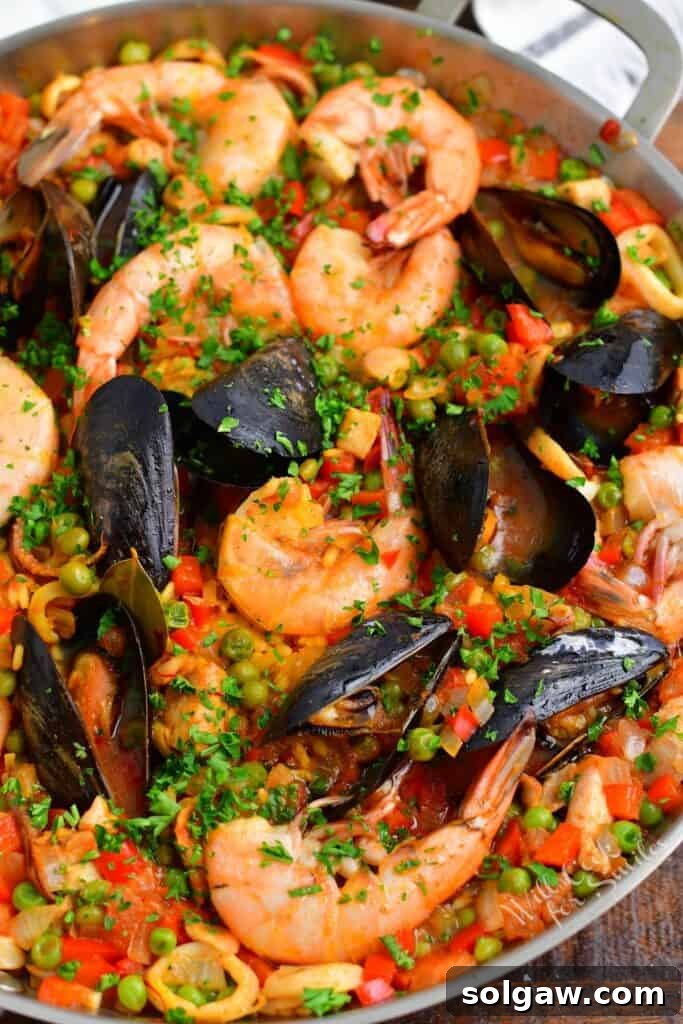 A Family's Cherished Paella 2 A metal pot is filled with a vibrant, freshly cooked paella, garnished with lemon wedges and parsley.