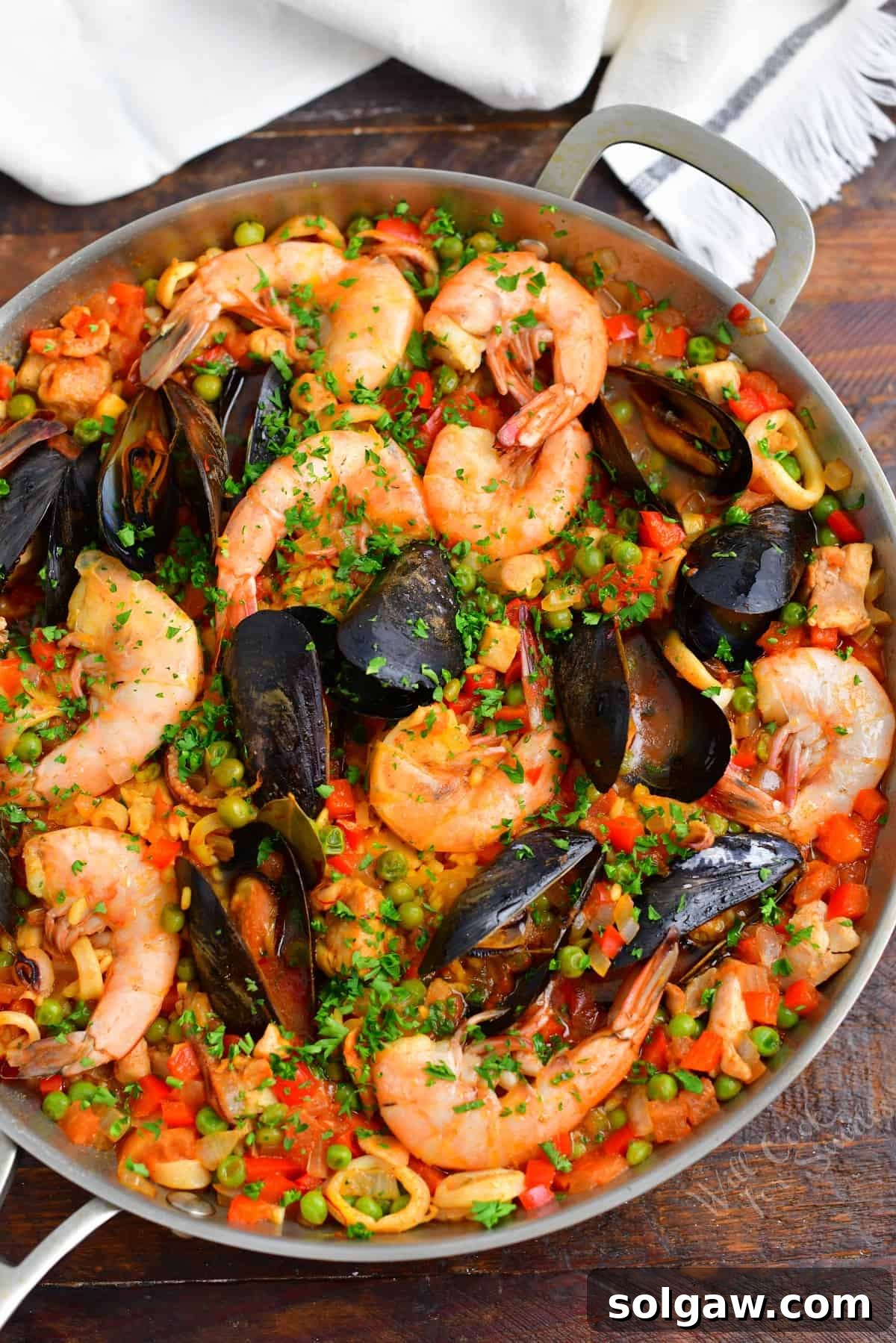 A Family's Cherished Paella 14 A large paella pan is brimming with a perfectly cooked chicken and seafood paella, garnished and ready for serving.