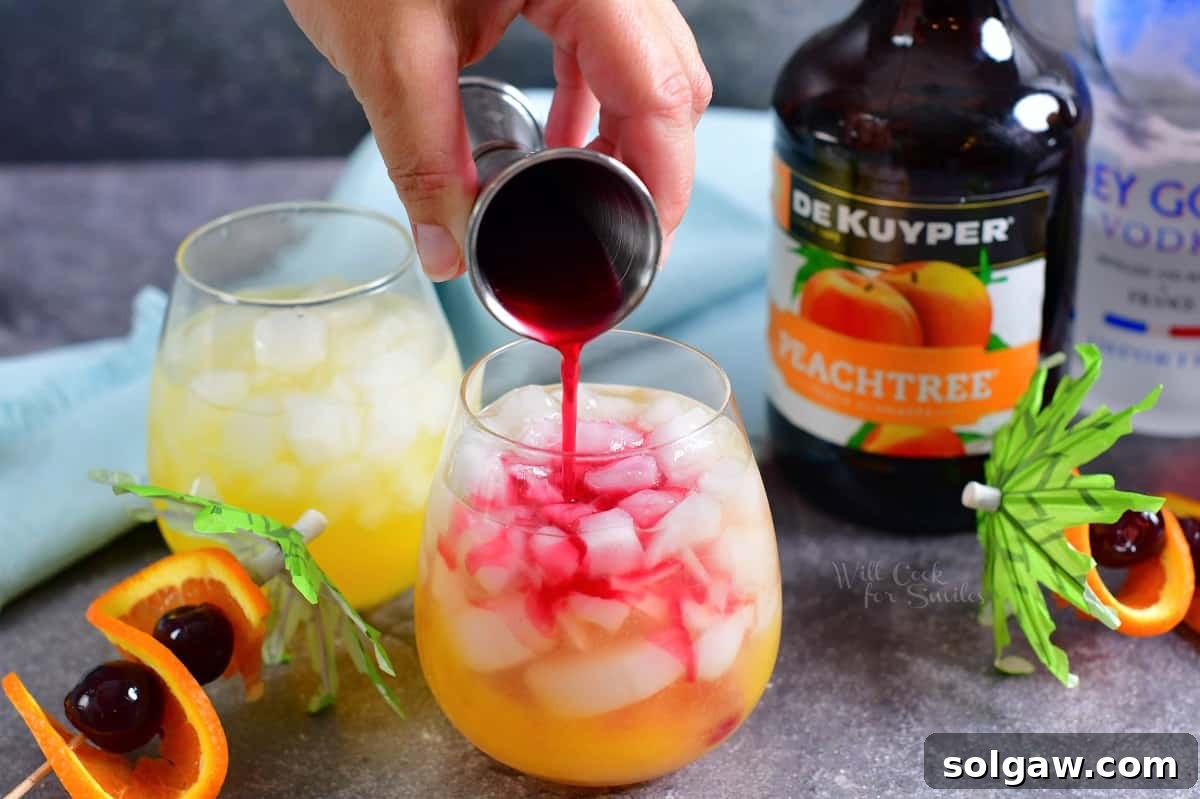 Cranberry juice, with its deep red hue, is gently poured into the glass, creating a beautiful contrast or a mixed blend.