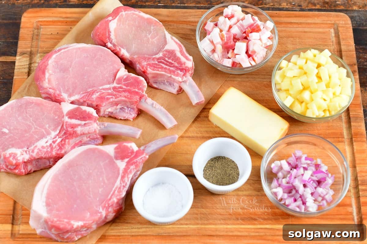 Fresh ingredients for the stuffed pork chops, including raw pork chops, crisp apples, uncooked bacon, shallots, and a block of smoked cheddar cheese, are artfully arranged on a rustic wooden cutting board, ready for preparation.