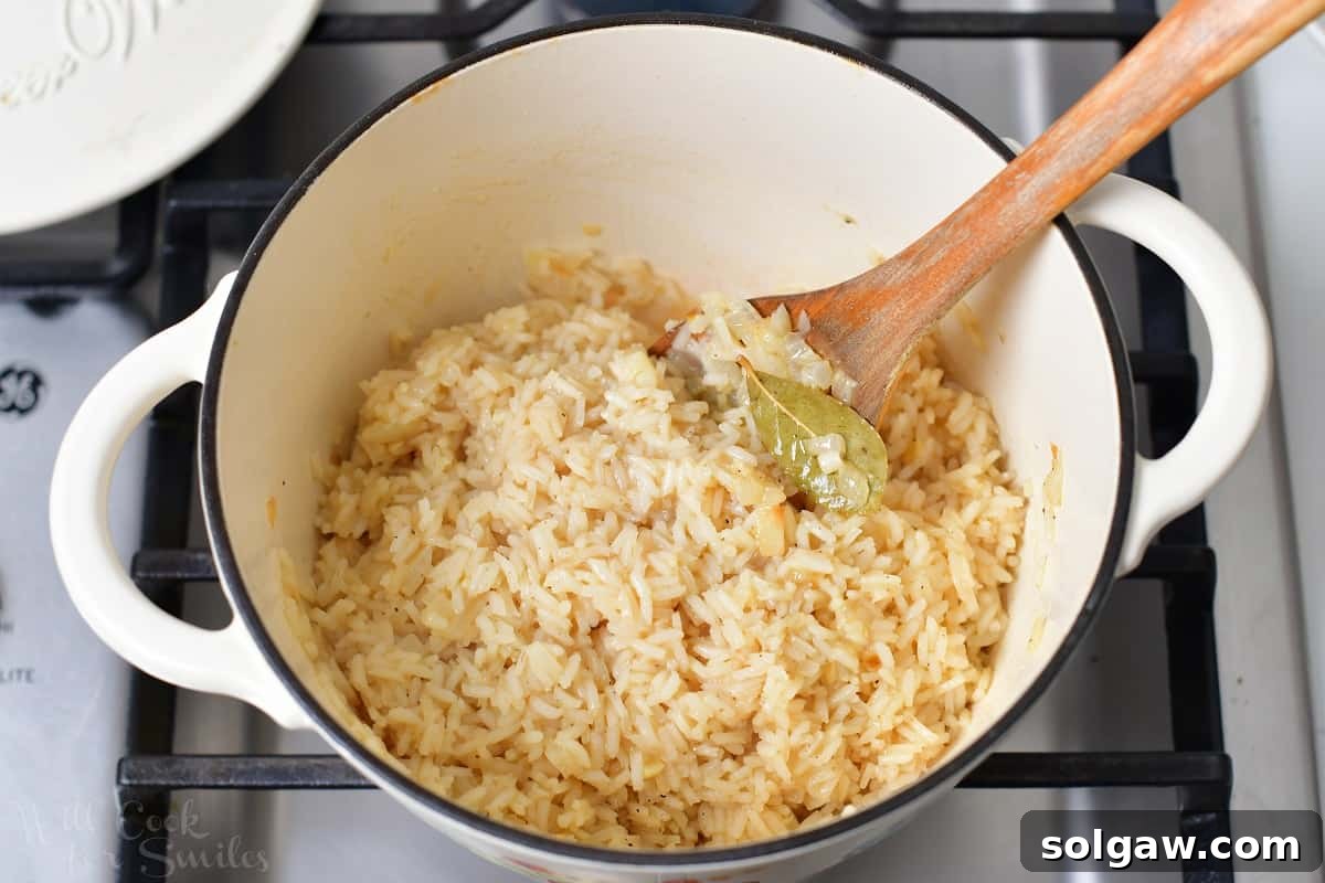 Cooked rice pilaf resting in the pot with the lid on, off the heat, allowing residual steam to finish the cooking process.