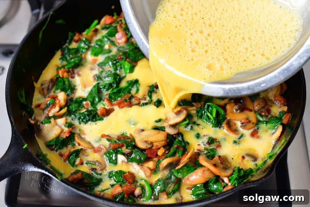 Simple Skillet Frittata 8 adding eggs to the cooked vegetables in a cast iron skillet