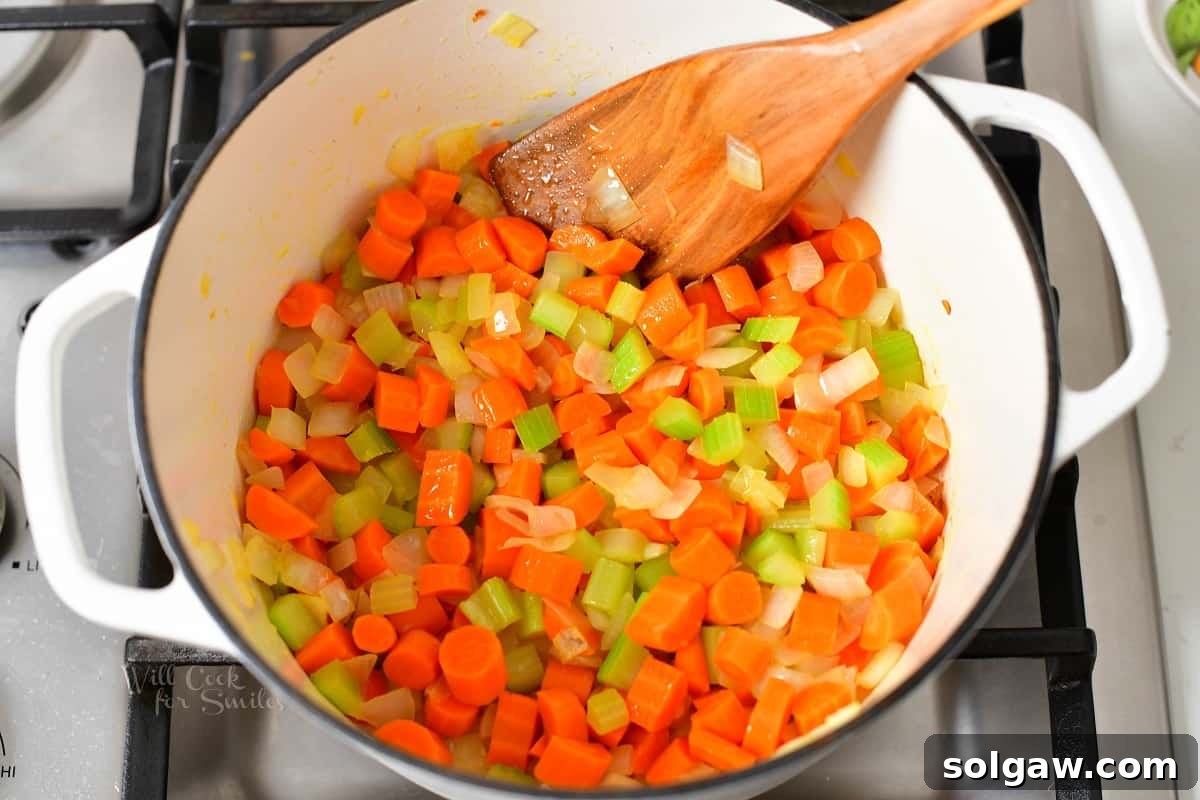 Diced onions, carrots, and celery sautéing in a Dutch oven until softened and browned.