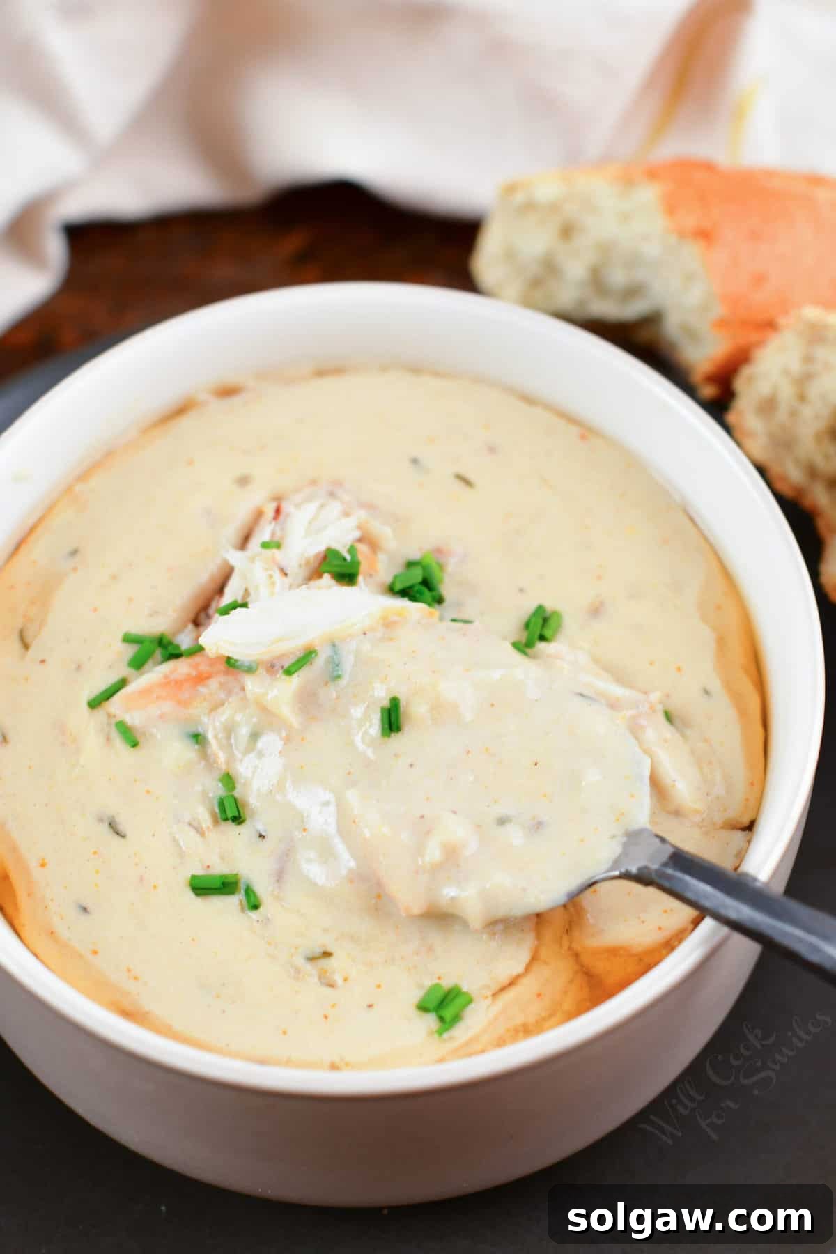 spooning some crab soup out of the bowl