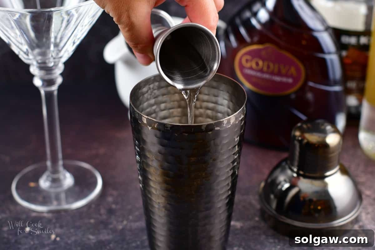 adding vodka to the cocktail shaker